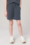 Girl wearing granite grey drawstring athleisure shorts with pockets and white sneakers