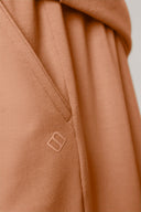 Close-up of mocha brown boys' athleisure shorts pocket with stitched logo detail