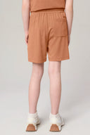 Girl wearing mocha brown athleisure shorts with elastic waistband and back pocket, rear view