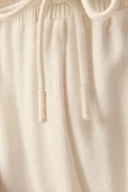 Close-up of beige athleisure shorts drawstring and elastic waistband