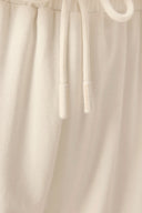 Close-up of beige athleisure shorts with drawstring waistband and soft fabric texture