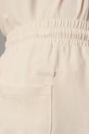 Close-up of beige girls' shorts with elastic waistband and front pocket
