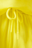 Close-up of yellow drawstring shorts with elastic waistband, summer activewear fabric