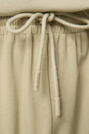 Close-up of beige athletic shorts with drawstring and elastic waistband detail