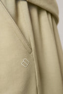 Close-up of light beige athleisure shorts pocket with subtle stitched seam and logo detail