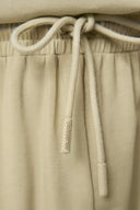 Close-up of beige drawstring shorts with elastic waist, soft fabric texture, athleisure style