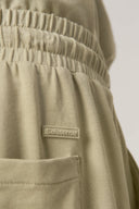 Close-up of light khaki girls' athleisure shorts with elastic waistband and pocket detail