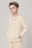 Boy in sand-colored kids UV hoodie with zipper and pockets, neutral background