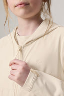 Close-up of girl wearing sand-colored kids UV hoodie with textured fabric and thumb hole cuff