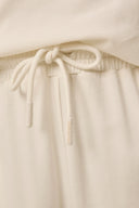 Close-up of kids' sand jogger pants with drawstring waist in cream color