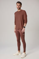 Man wearing sepia brown long-sleeve activewear top and matching performance tights