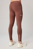 Rear view of person wearing sepia brown athletic leggings with side pocket and reflective details