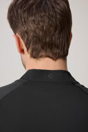 Back view of a man wearing a charcoal athletic fitted jacket with textured fabric