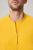 Close-up of a man wearing a mustard yellow zip-up athletic jacket with textured fabric.