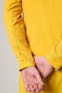 Close-up of yellow fitted athletic jacket with perforated mesh sleeve detail