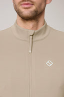 Close-up of man wearing beige zip-up athleisure jacket with high collar