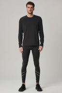 Man wearing charcoal long sleeve activewear shirt and athletic leggings with reflective stripes