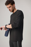 Man in charcoal long sleeve active tee with water bottle, athleisure apparel