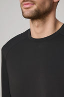 Close-up of man wearing charcoal long sleeve active tee with crew neck.