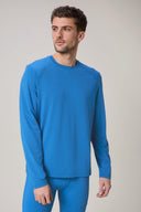 Man wearing cobalt blue long sleeve active tee and leggings, studio background, athleisure