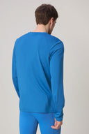 Man wearing cobalt blue long sleeve athletic shirt and leggings, back view