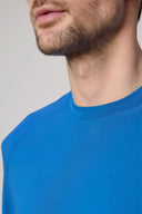 Close-up of a man wearing a cobalt blue activewear tee with subtle logo detail