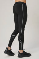 Back view of person wearing charcoal reflective leggings with contour lines and black sneakers