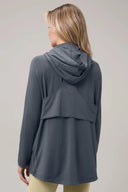 Back view of a woman wearing a granite grey long sleeve athletic hoodie with mesh panel detail.