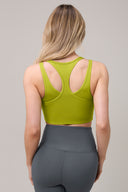 Woman wearing a green racerback yoga bra and high-waisted gray leggings, back view