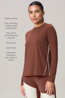 Woman wearing sepia long sleeve athletic top with moisture-wicking, quick-dry fabric