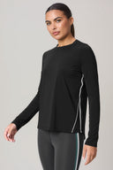 Woman wearing charcoal long sleeve sweater with white accent line, athleisure style