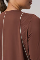 Close-up of sepia long sleeve activewear with mesh panel and white seam detail