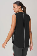 Woman wearing sleeveless charcoal athletic top with white piping, viewed from the back