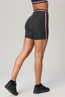 Charcoal high-waisted bike shorts with side stripes, modeled in studio setting