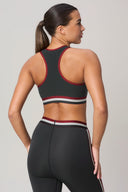 Woman wearing charcoal racerback sports bra and matching high-waist leggings, back view