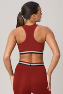 Woman from behind wearing a red racerback sports bra and high-waisted leggings
