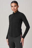 Woman wearing charcoal athletic jacket with full zip and perforated side panels
