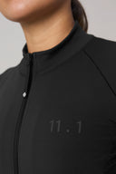 Close-up of a black athletic jacket with zipper and subtle '11.1' detail on chest