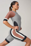 Woman in modern colorblock rash guard athletic bodysuit with rust, black, and gray accents