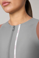 Close-up of woman wearing grey and mauve rashguard with front zipper and contrast trim