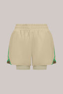Pale olive green athletic shorts with built-in liner and green trim, elastic waistband, front view.
