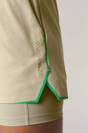 Close-up of pale olive athletic shorts with green trim and inner layer detail