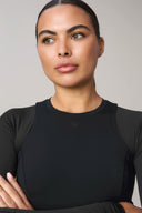 Woman wearing charcoal long-sleeve active tee, close-up of upper body and face