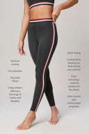 High-rise charcoal leggings with red and white side stripes, featuring moisture-wicking, UV protection, 4-way stretch, and quick-drying recycled fabric.