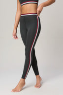 Charcoal high-waisted leggings with burgundy and white side stripes, barefoot model