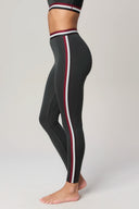 Woman modeling charcoal athletic leggings with burgundy and white side stripes