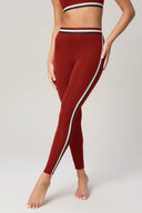 Woman wearing high-waisted merlot leggings with contrast side stripes for activewear
