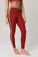 Woman wearing high-waisted merlot red leggings with sporty side stripes