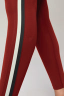 Close-up of merlot red leggings with black and white side stripe, activewear style